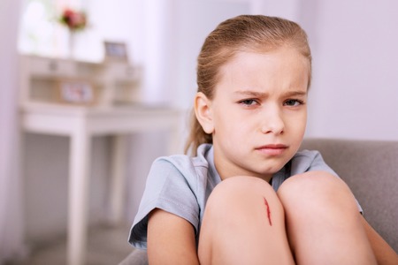 So sad. Cheerless gloomy girl looking at you while feeling upsetの写真素材