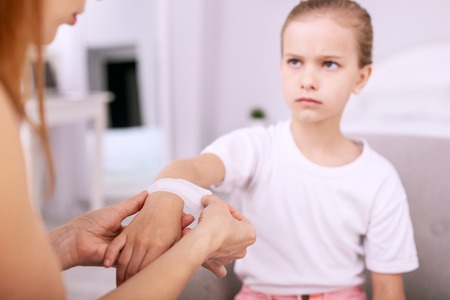 Medical aid. Selective focus of a medical plaster being put on the girls handの写真素材