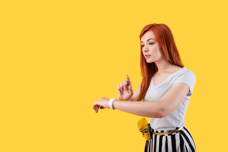 Modern innovations. Pleasant young woman using a smartwatch while wearing it on her wristの写真素材
