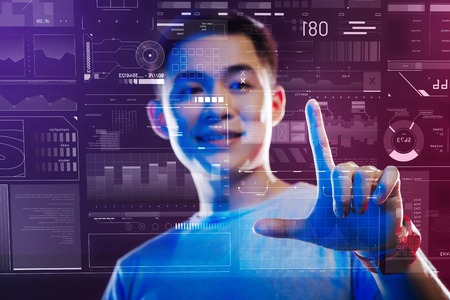 Smart touch. Young handsome IT manager using touch screen while working