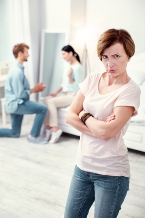 Bad news. Upset depressed mother in law looking at you while being unhappy about her sons marriageの写真素材