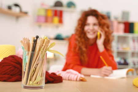 Art project. Red-haired art student feeling extremely overloaded while getting ready for her future art projectの写真素材