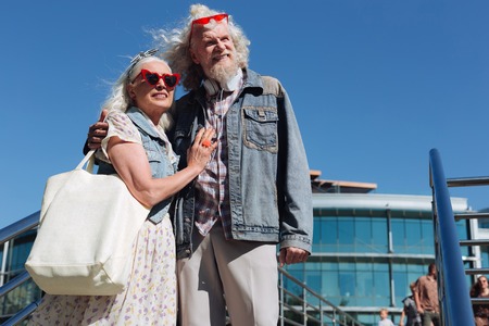 My husband. Pleasant aged woman standing near her husband while hugging himの写真素材