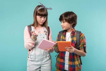 My best friend. Cheerful handsome boy holding his tablet and looking at the girlの写真素材