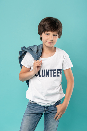 My uniform. Delighted young boy smiling and holding his jacketの写真素材