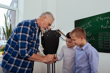 At school. Nice pleasant boys standing together while learning about modern technology