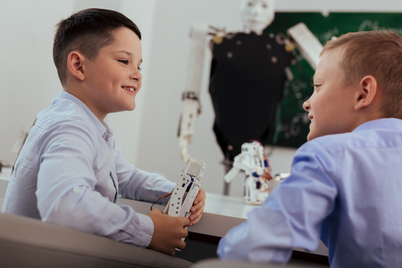 School break. Happy positive boy smiling while talking to his friend during a school breakの写真素材