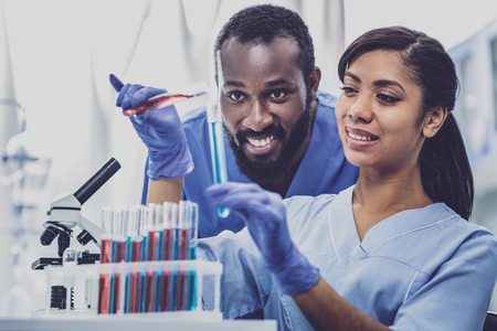 Working together. Couple of two young promising chemists enjoying working together in laboratory greatlyの写真素材
