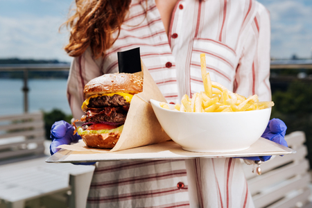 Yummy food. Close up of yummy delicious double meat burger and fries on big white plateの写真素材