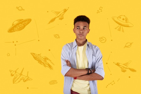 Space dreams. Calm young person standing with his arms crossed and looking into the distance while dreaming about flying into the open space and meeting aliensの写真素材