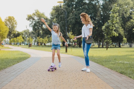 Open air. Good-looking beautiful smiling active mother and daughter spending time on open air