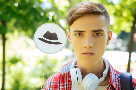 Thinking hats. Green-eyed progressive student gathering available information while using technique of thinking hatsの写真素材