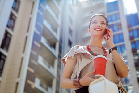 Pleasant mood. Happy joyful woman smiling while having a phone conversationの写真素材