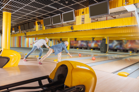 Who is better. Nice skilled men hitting balls while participating in the bowling competitionの写真素材