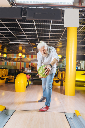Games for adults. Delighted nice man throwing a watermelon while having funの写真素材