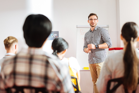Confident speaker. Smart professional businessman smiling and looking at his audience while taking about personal growthの写真素材