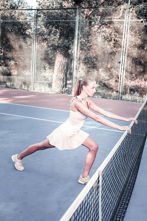 Healthy lifestyle. Ambitious female player wearing sport form and stretchingの写真素材