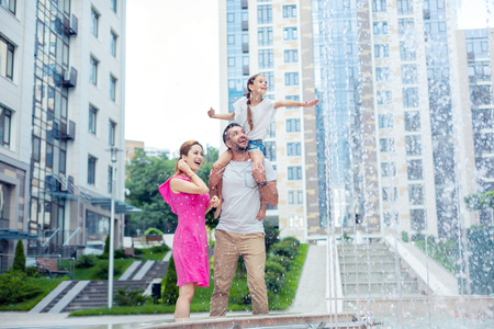 So beautiful. Delighted happy family standing together while looking at the beautiful fountainの写真素材