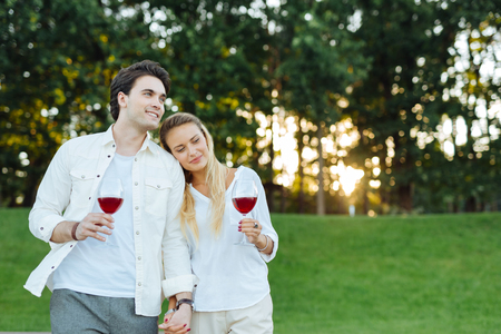 We are together. Happy positive couple holding their hands while being outdoors togetherの写真素材