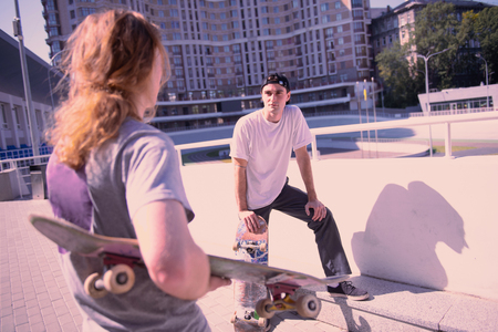 Males activities. Pleased young man leaning on knee while listening to his partnerの写真素材