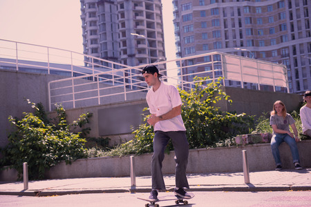 Pay attention. Handsome male person looking forward while standing on skateboardの写真素材
