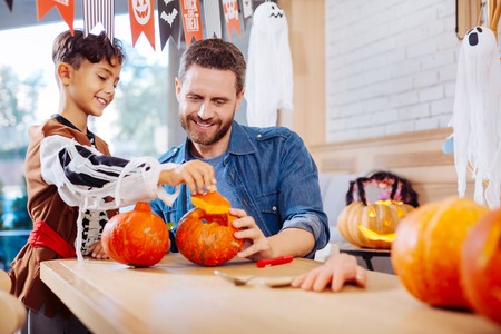 Excited boy. Dark-haired boy wearing Halloween costume feeling excited before party standing near his fatherの写真素材