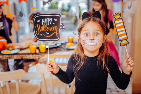 Cat girl. Cute dark-eyed little girl wearing cat suit feeling simply amazing and entertained while having much funの写真素材