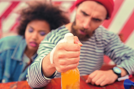 Beer foam. Exhausted man having hard morning after a big party and looking at the beer foamの写真素材