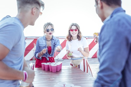 Give it back. Pleased female person standing near table while pointing at yellow ballの写真素材