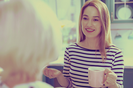 Good day. Cheerful young female expressing positivity while looking at her momの写真素材