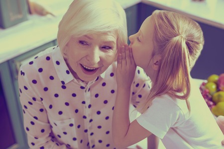 Enigmatical smile. Cheerful mature woman keeping smile on her face while being in all ears