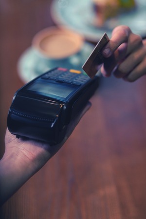 My credit card. Young woman holding card while doing paymentの写真素材