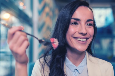 Charming brunette. Pretty girl expressing positivity while going to eat cakeの写真素材