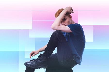 Go away. Displeased brutal guy looking at camera and sitting in profileの写真素材