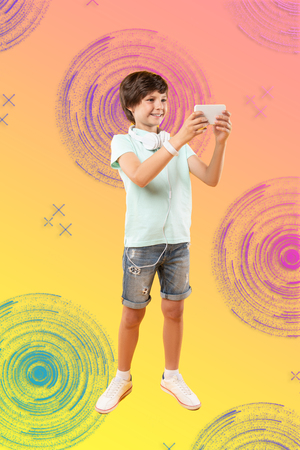 Interesting game. Happy optimistic boy carrying phone and grinningの写真素材