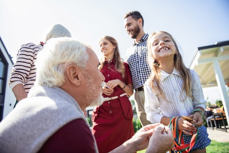 Real emotions. Happy parents keeping smile on faces while standing on the backgroundの写真素材