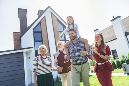 Lets go. Pretty senior female holding hand of her husband while walking in street togetherの写真素材