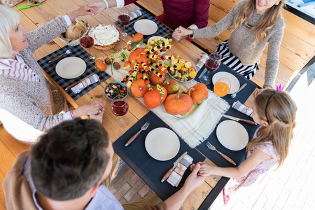 Vegetarian menu. Kind little girl sitting in semi position and looking at colorful pumpkinsの写真素材