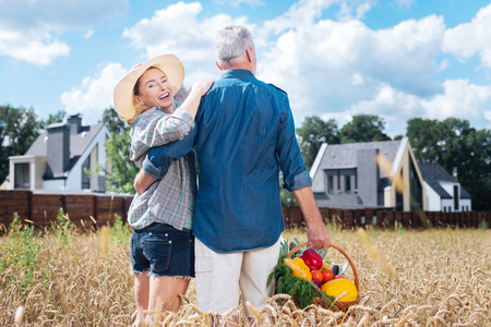 Love and protection. Beautiful mature woman feeling loved and protected standing hear her strong supportive husbandの写真素材