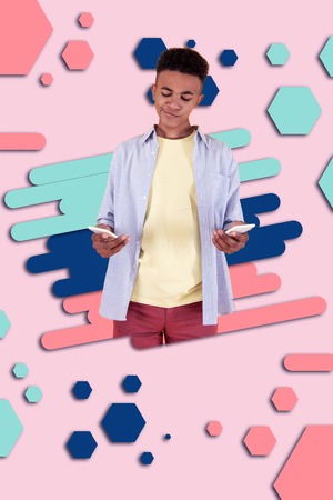 Electronic store. Mulatto boy standing in front of graphic background having hesitations while...