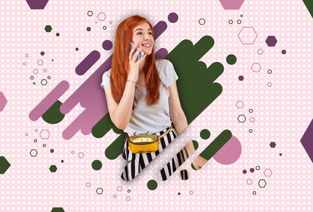 Colorful background. Cheerful red-haired student wearing stylish clothes standing ahead of colorful graphic backgroundの写真素材
