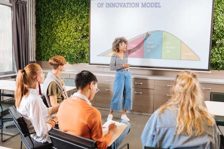 Innovation model. Group of attentive students making notes while studying consciouslyの写真素材