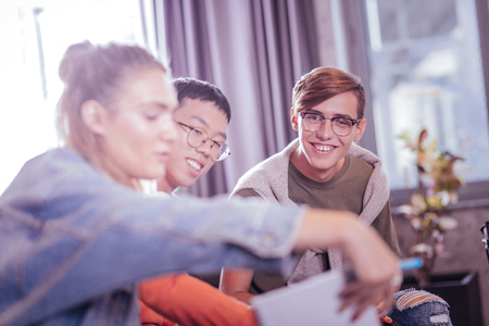 My colleagues. Handsome boy expressing positivity while posing on cameraの写真素材