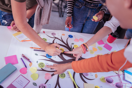 Family tree. Kind male person bowing head while pointing at project workの写真素材