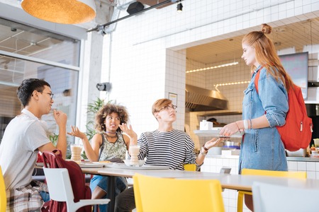 No place here. Pretty girl holding her tray with food while standing near tableの写真素材