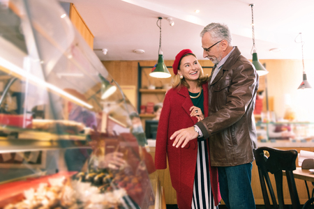 French couple. Beautiful French couple coming to cozy bakery in the morning for buying some croissantsの写真素材