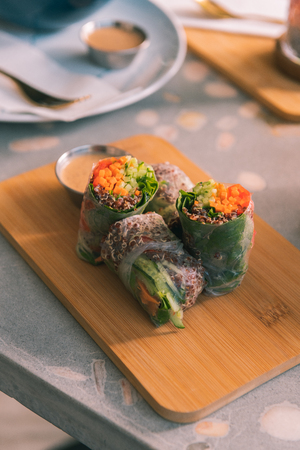 Spring rolls. Close op of healthy yummy spring rolls stuffed with some vegetables lying on wooden deskの写真素材