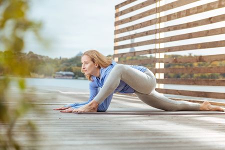 Outdoor exercises The young and motivated woman practicing stretching exercisesの写真素材