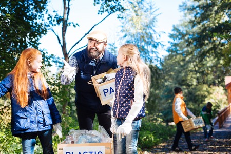 Team leader. Nice positive girls looking at the bearded man while listening to his directionsの写真素材
