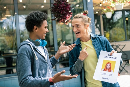 My search. Positive nice man pointing at himself while holding an advertisement about a missing girlfriendの写真素材